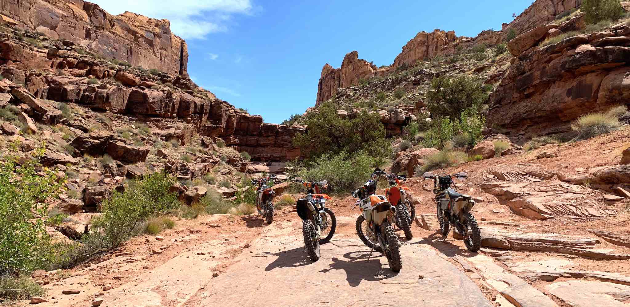 Five dirt bikes surrounded by rocky cliffs in Utah