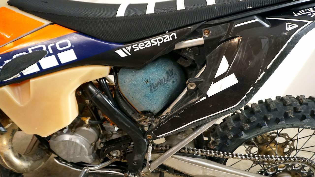 A cleaned and oiled dirt bike air filter installed in the air box
