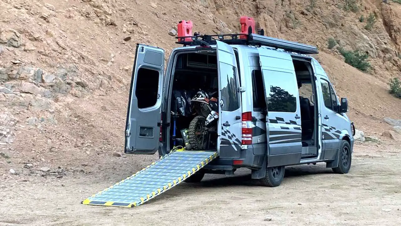 Motovan with rear doors open to show a dirt bike loaded in with a loading ramp