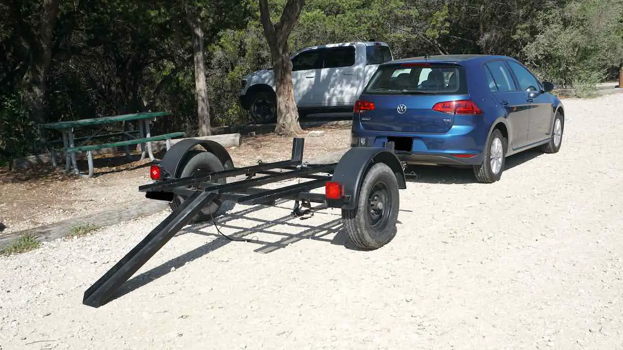 Dirt bike trailer with a loading ramp attached to a car