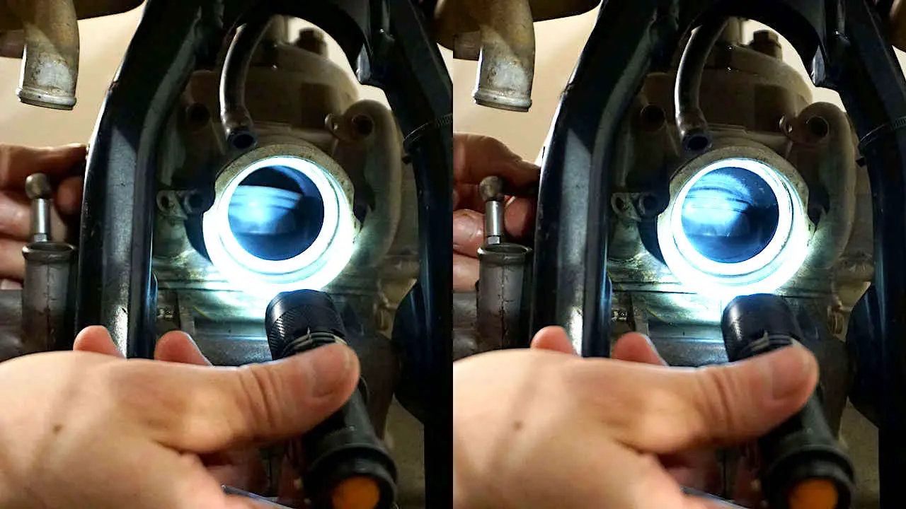 Hand holding a flashlight and pointing through exhaust port at the 2 stroke power valve when fully open and fully closed