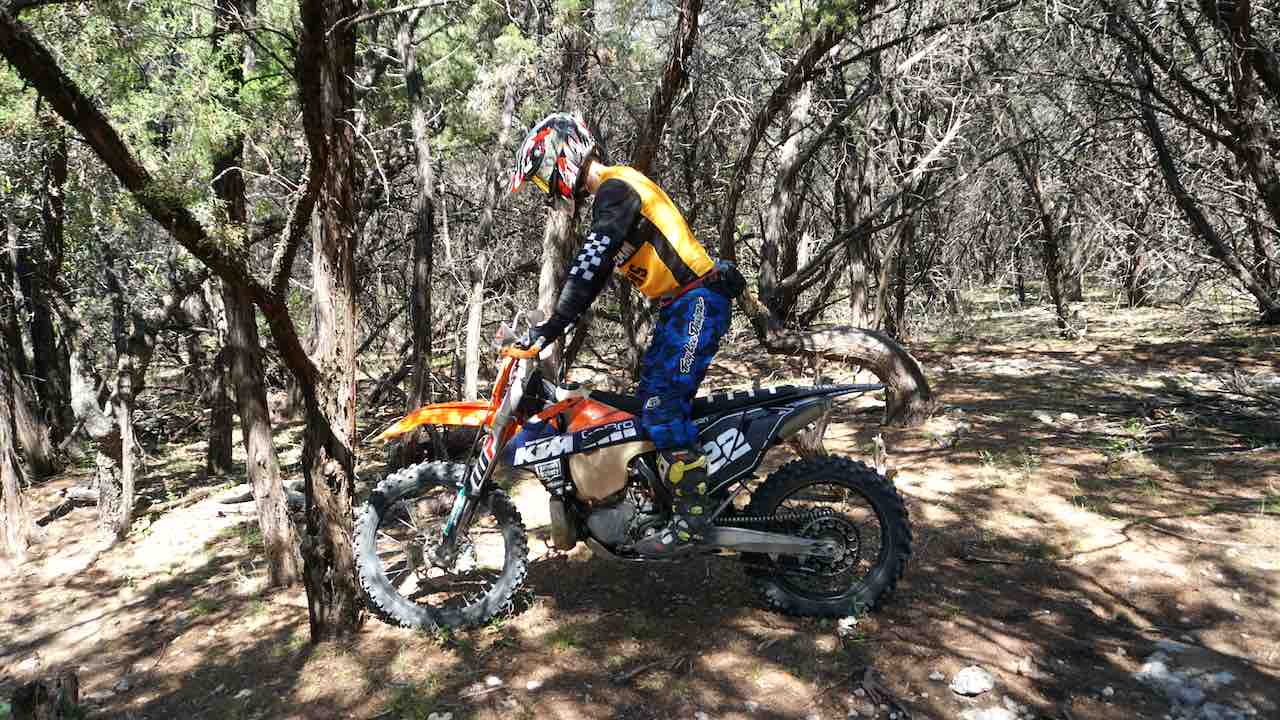 Rider standing on the foot pegs on a dirt bike practicing static balance