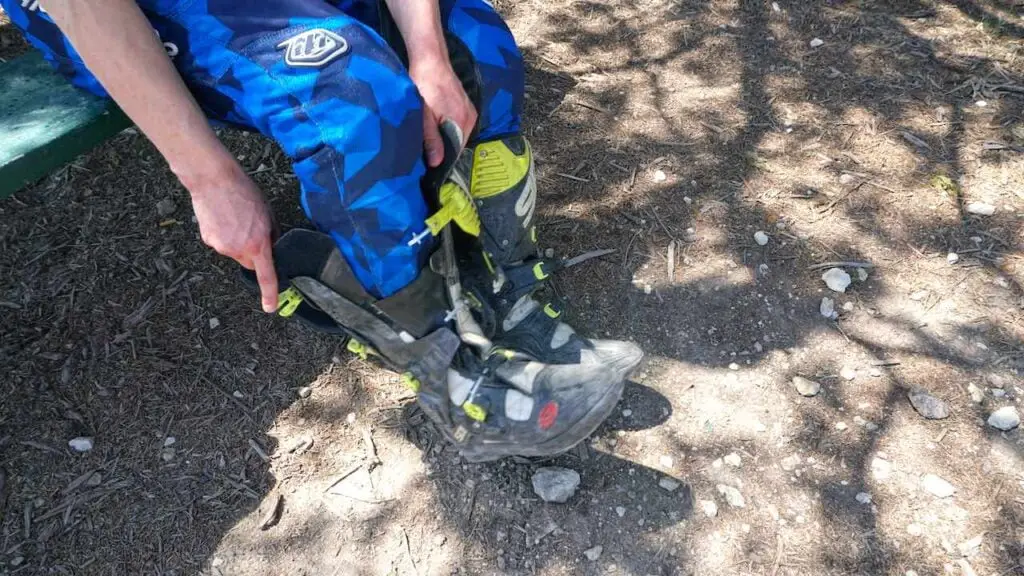 Off-road ride putting on dirt bike boots and gear