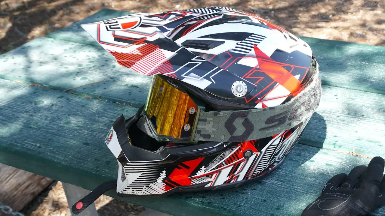 Dirt bike helmet with goggles on a green table top