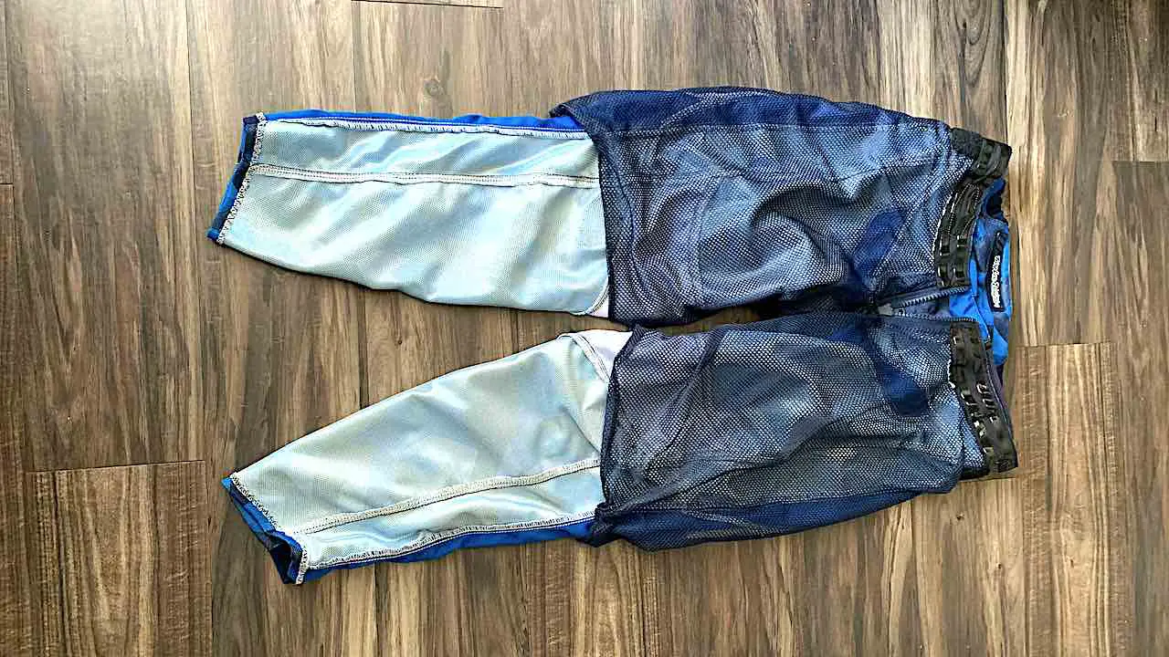 Dirt bike pants turned inside out to show mesh inner liner, laid on the floor