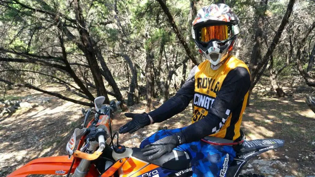 Dirt bike rider stretching hands to avoid carpal tunnel syndrome