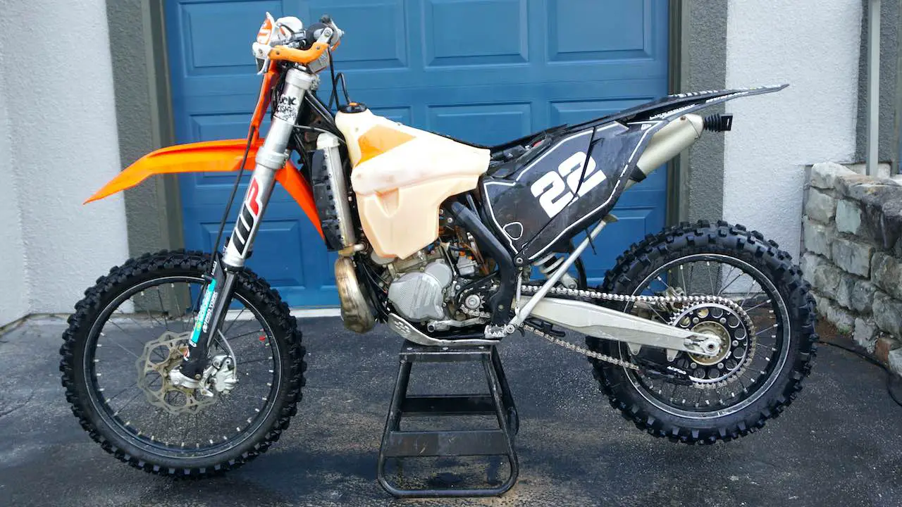 Enduro bike on a center stand ready to remove the fuel tank.