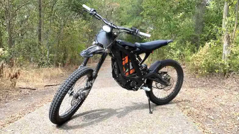 Electric dirt bike Sur-Ron on a side stand trailside