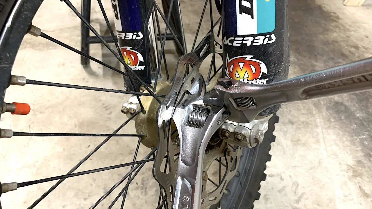 Using two wrenches to bend the brake disc arm to true