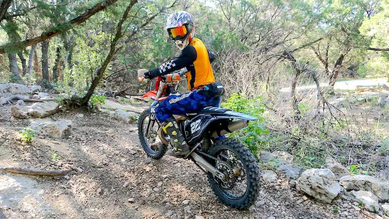 A dirt bike rider testing the best dirt bike for trail riding on a single track