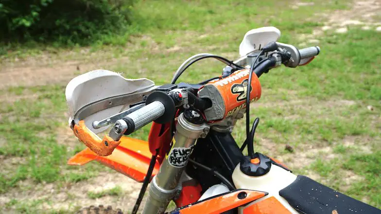 Close up of a dirt bike handlebar taken from the left side before adjusting brake and clutch levers