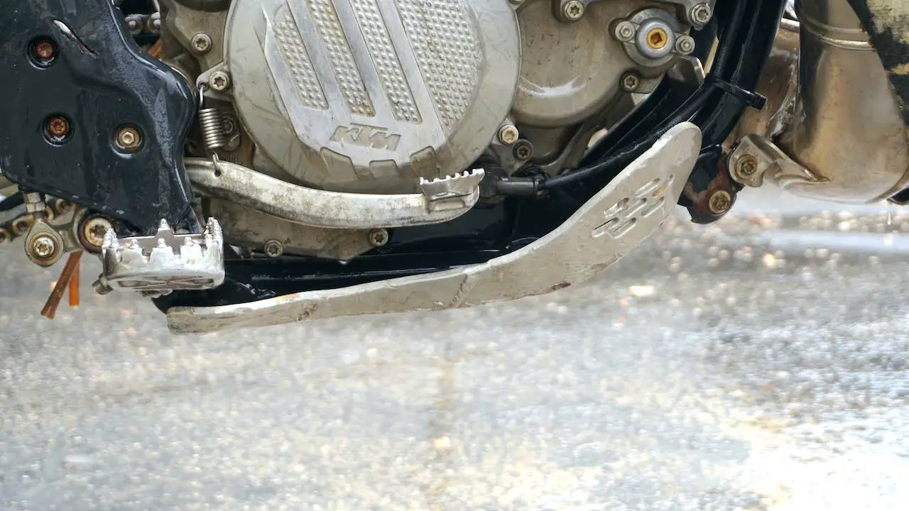 Side view of a dirt bike with an aluminum dirt bike skid plate installed to the frame