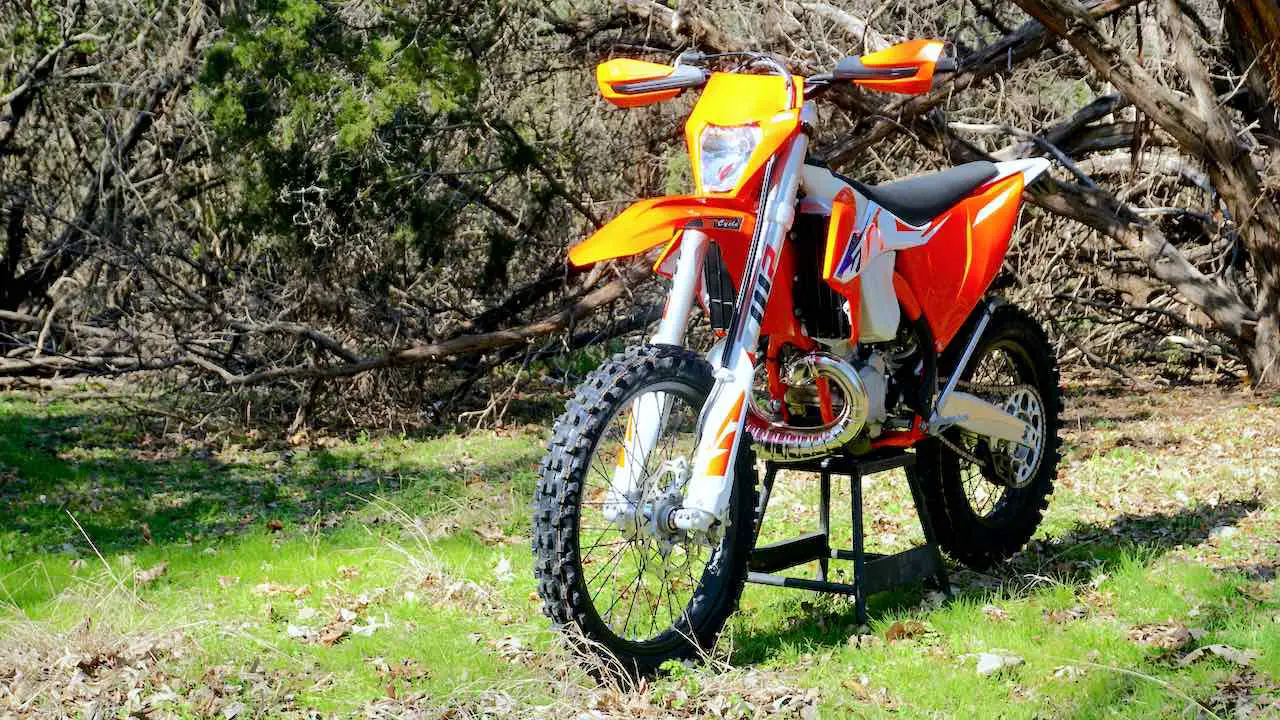2023 KTM XC-W 300 on a center stand against a forest background