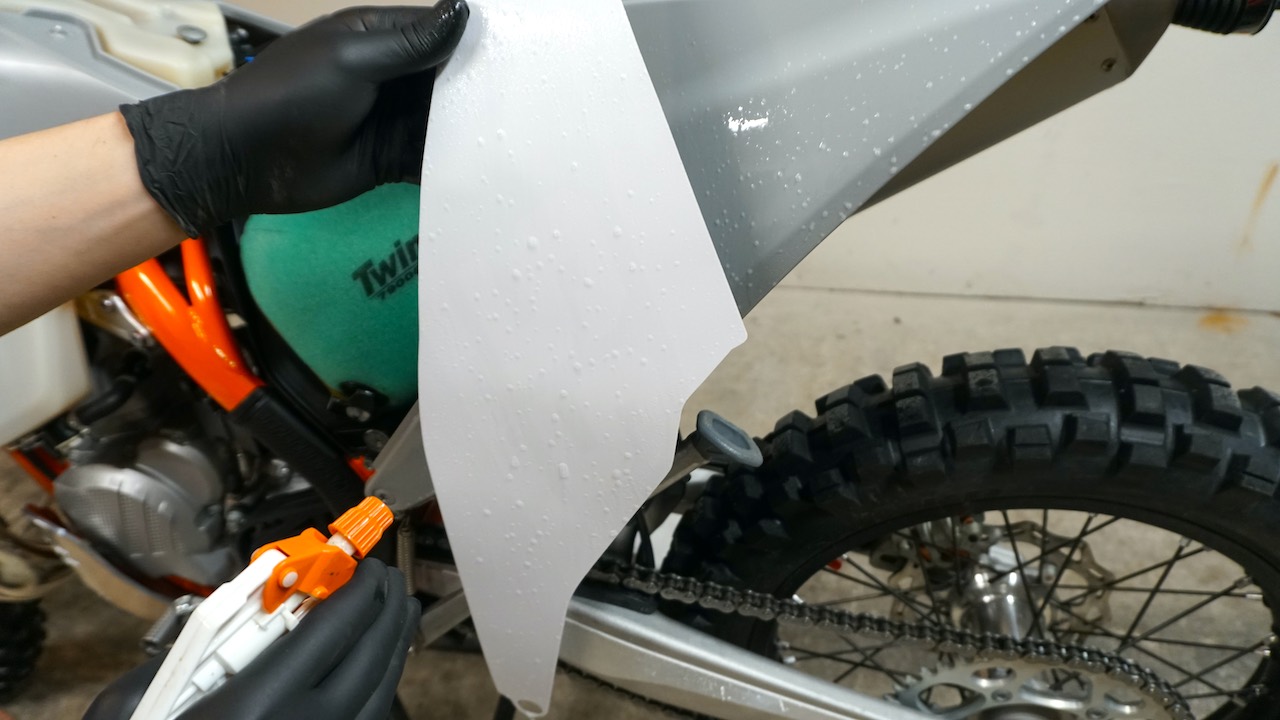 Soapy water sprayed on dirt bike graphics to ease installation process