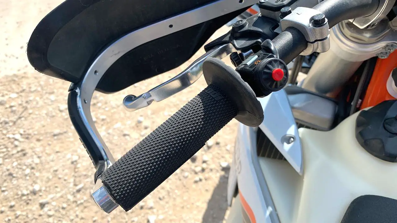 Dirt bike grips with wrap-around hand guards installed on a KTM.